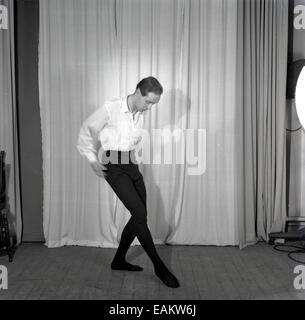 1950er Jahre, historisches Bild eines männlichen Balletttänzers, der seine Bewegungen auf einem hölzernen Bühnenboden vor einem Vorhang übt oder einstudiert Stockfoto