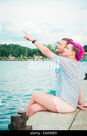 Mann und Frau sitzen am Abend am Ufer Flusses Stockfoto