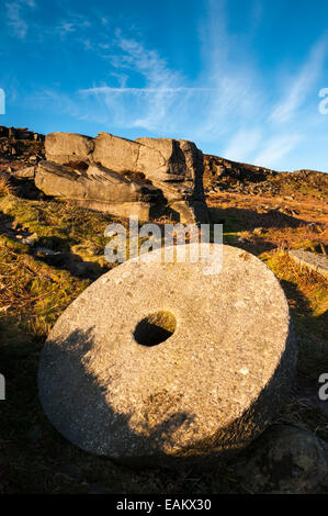 Runde Mühlstein unten Stanage Edge in th Peak District, Derbyshire in Abend Sonne. Stockfoto