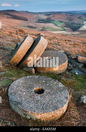 Mühlsteine unter Stanage Edge bei Sonnenuntergang. Blick über die farbenfrohe Landschaft mit der Straße in der Ferne. Stockfoto