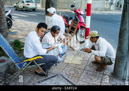 Menschen, die ein vietnamesischer Brettspiel nennen Xiangqi, wie Schach oder Dame, auf dem Bürgersteig in Can Tho, Mekong-Delta, Vietnam. Stockfoto