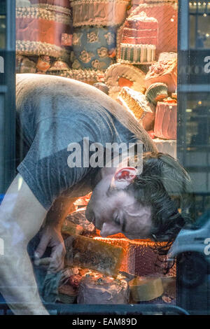 New York, USA. 17. November 2014; eilen zur Fristwahrung, junger Mann arbeitet ruhig um das letzte kleine Bergdorf Goodman Weihnachten Fenster abzuschließen mit den Herrlichkeiten des Gebäcks, bevor die 18:00 Enthüllung Credit: Dorothy Alexander/Alamy Live News Stockfoto