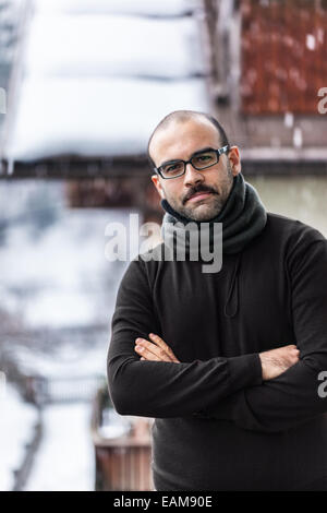 eine Glatze Mann mit Schnurrbart tragen Winterkleidung in einem verschneiten Tag Stockfoto