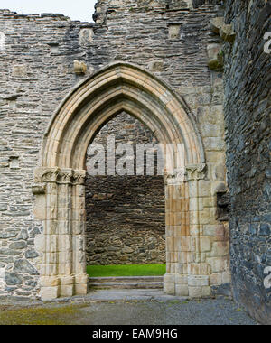 Verziert gewölbten Eingangsbereich durch graue Steinmauer im 13. Jahrhundert, die Ruinen von Valle Crusis Abtei in der Nähe von Llantysilio in Wales Stockfoto