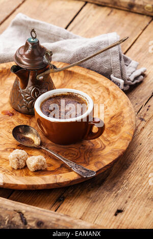 Tasse schwarzen Kaffee und türkischen Cezve auf hölzernen Hintergrund Stockfoto