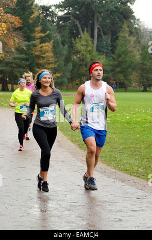 Paar Hand in Hand läuft an der Cardiff 5k Morun, Cardiff 2014 Teil der Movember Mens Gesundheit Fundraising-Veranstaltungen Stockfoto
