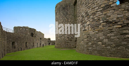 Blick auf große innere des historischen Beaumaris Castle mit immensen Steinmauern Schattierung Rasen und unter blauem Himmel in Wales Stockfoto