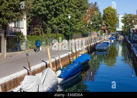 Lady Spaziergänge entlang ruhigen Kanal auf der Insel Lido in Venedig, Italien, 21. Oktober 2011: Stockfoto