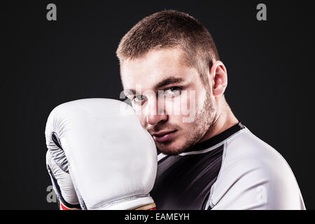 eine junge Kickboxer oder Boxer über einen schwarzen Hintergrund isoliert Stockfoto