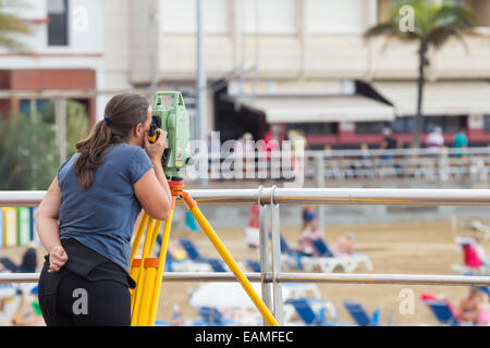 Frau mit Theodolit am Strand in Spanien Stockfoto