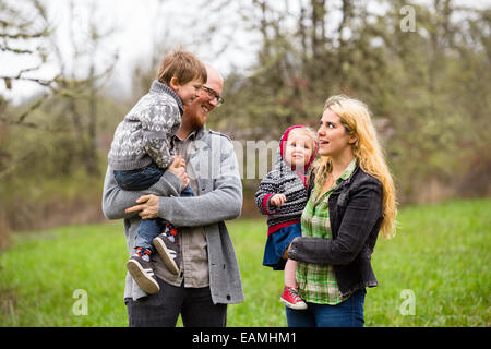 Lifestyle Portrait eine vierköpfige Familie mit Mutter, Vater, Sohn und Tochter Interaktion mit Glück. Stockfoto