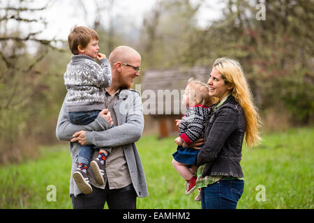 Lifestyle Portrait eine vierköpfige Familie mit Mutter, Vater, Sohn und Tochter Interaktion mit Glück. Stockfoto