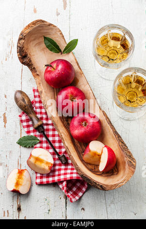 Rote Reife Äpfeln in Olive Holz Schüssel und Vintage Core remover Stockfoto