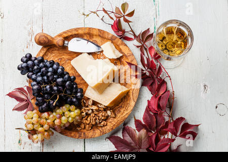 Parmesan-Käse und Trauben auf Oliven Holzplatte und Wein Stockfoto