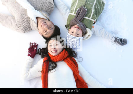 Orientalische Familie im Schnee liegen Stockfoto