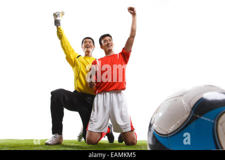 Zwei Fußballer feiern Erfolg kniete sich auf dem Rasen Stockfoto