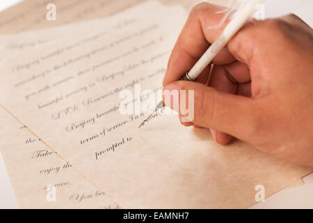 Eines Mannes Hand, die eine Feder Stifte in schriftlicher Form Stockfoto