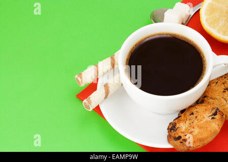Kaffee, Waffeln und Gebäck auf grünem Hintergrund Stockfoto