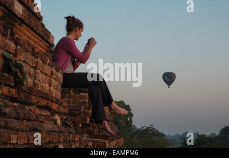 Touristischen beobachten, fotografieren Sonnenaufgang von den Wänden des Tempels mit Heißluftballons schweben Flug über Heide, Bagan, Burma, Myanmar Stockfoto