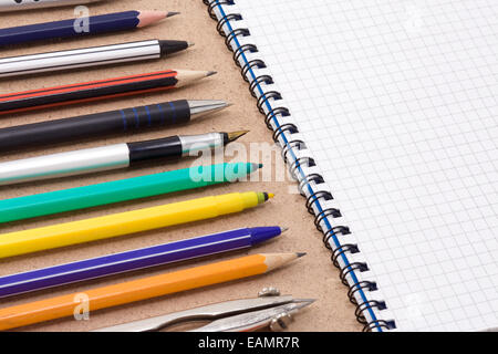 Kugelschreiber, Bleistift und Filzstift mit geprüften Notebook auf Holzstruktur Stockfoto