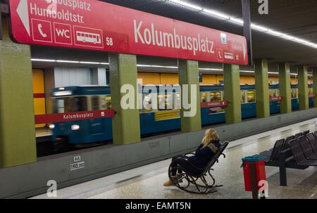 München, Deutschland. 17. November 2014. Eine junge Frau sitzt und spricht am Telefon in einem Schaukelstuhl auf der Plattform des Kolumbusplatz U-Bahn Station in München, 17. November 2014. Es ist nicht bekannt, warum sie saß auf dem Stuhl auf der Plattform. Foto: PETER KNEFFEL/Dpa/Alamy Live News Stockfoto