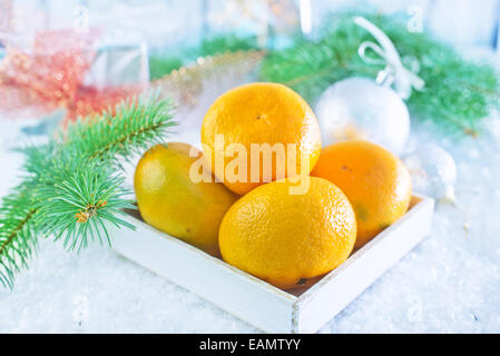 Mandarinen in Holzkiste und auf einem Tisch Stockfoto