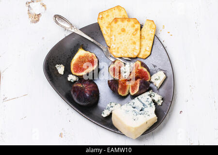 Feigen mit Roquefort Käse und Cracker auf Keramikplatte. Ansicht von oben. Stockfoto