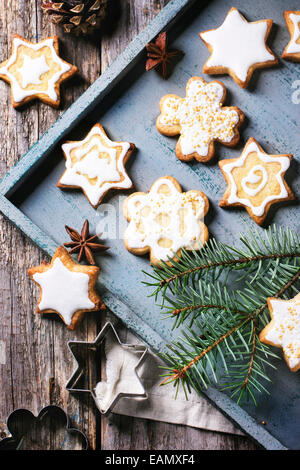 Sortiert von Weihnachtsgebäck auf Holztablett mit Weihnachtsbaum Zweig über alte Tisch serviert. Stockfoto