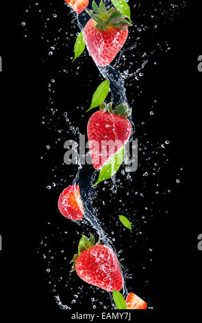 Erdbeeren im Wasser planschen, auf schwarzem Hintergrund isoliert Stockfoto