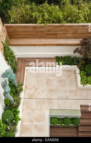 Über Ansicht der Stadt Garten in London mit Bronze Statuen und gemischte Pflanzung, mit gepflasterten Terrasse und Treppen, die um zu niedrigeren Niveau, Chelsea, UK Stockfoto