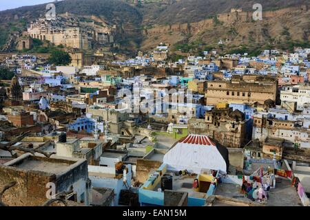 Indien, Rajasthan, Mewar, Bundi, Stadtschloss im Hintergrund, Frauen im Chat auf dem Dach der Altstadt mit den blauen Häusern Stockfoto