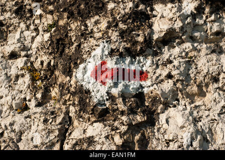 Roter Pfeil markiert eine touristische Route auf einem Felsen Stockfoto
