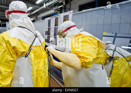 Würzburg, Deutschland. 3. November 2014. Die Teilnehmer kleiden im Rahmen eines Workshops zur Vorbereitung für den Einsatz in Krisengebieten auf einer Ebola-Fortbildungsseminar in Würzburg, Deutschland, 3. November 2014. Nach der Bundeswehr hat renommierte das einzige Ebola-Training-Center bis heute. Deutsche Entwicklungshelfer in Krisengebieten und in deutschen Isolierung Stationen trainieren hier. Foto: DANIEL KARMANN/Dpa/Alamy Live News Stockfoto