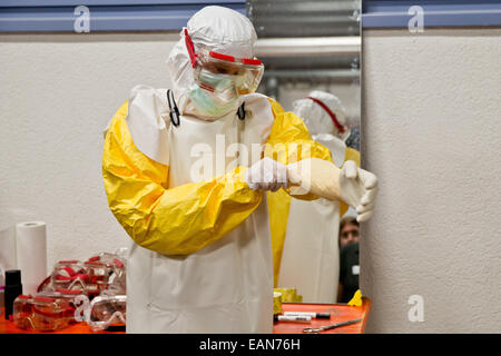 Würzburg, Deutschland. 3. November 2014. Gesundheit Profi Christian Kleine erklärt der richtigen Weg, um auf Schutzkleidung auf einer Ebola-Fortbildungsseminar in Würzburg, Deutschland, 3. November 2014 setzen. Nach der Bundeswehr hat renommierte das einzige Ebola-Training-Center bis heute. Deutsche Entwicklungshelfer in Krisengebieten und in deutschen Isolierung Stationen trainieren hier. Foto: DANIEL KARMANN/Dpa/Alamy Live News Stockfoto