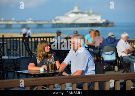 Erwachsenes paar genießen einen frühen Abend trinken zusammen in einem Strandcafé an der Strandpromenade in Eastbourne. East Sussex. UK Stockfoto