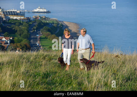 Ein älteres paar Spaziergang mit seinem Hund auf den South Downs, Eastbourne. East Sussex, UK Stockfoto