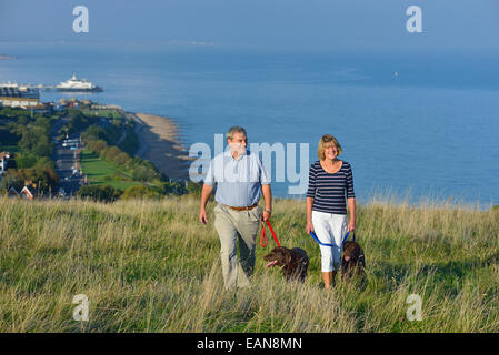 Ein älteres paar Spaziergang mit seinem Hund auf den South Downs, Eastbourne. East Sussex, UK Stockfoto