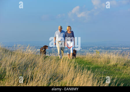 Ein älteres paar Spaziergang mit seinem Hund auf den South Downs, Eastbourne. East Sussex Stockfoto
