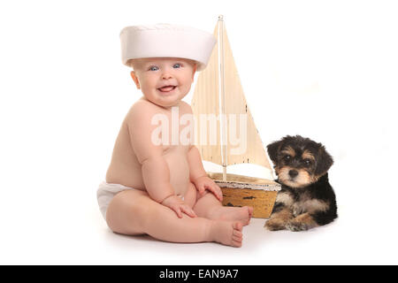 Niedliche Baby Boy mit seinem Haustier Teetasse Yorkie Welpen Stockfoto