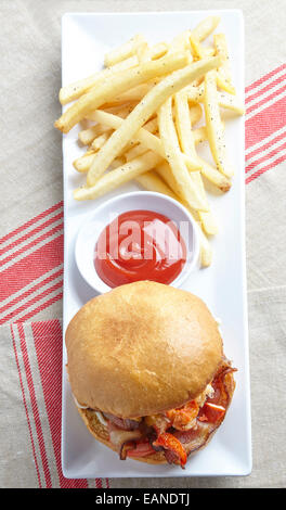 Main Lobster BLT-Tomaten-Mayo auf Brioche Rollen auf einem weißen Teller mit Ketchup und Pommes frites Stockfoto