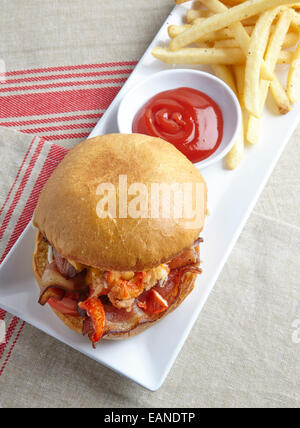 Main Lobster BLT-Tomaten-Mayo auf Brioche Rollen auf einem weißen Teller mit Ketchup und Pommes frites Stockfoto