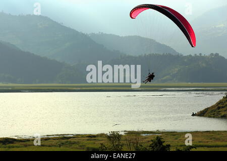 POKHARA, NEPAL - Oktober 11: Gleitschirm ist am Ufer des Phewa Tal-Sees 5,23 km2 landen nach dem Sprung aus der weniger Stockfoto