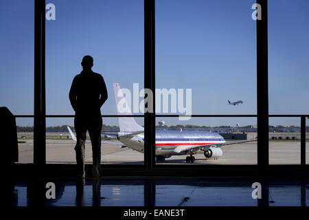 Mann starrte Out Flughafen Fenster beobachten Flugzeuge Stockfoto