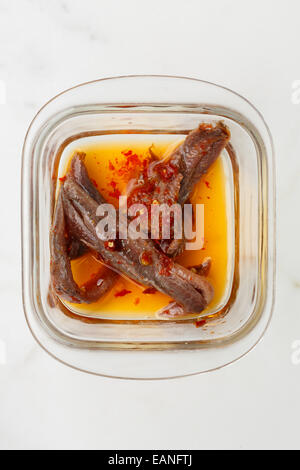 sizilianische Sardellen Filets mit Chilipfeffer und Öl in eine Glasschüssel Stockfoto