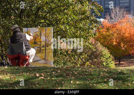 Ein reifer männlicher Maler arbeitet auf einer Staffelei, Central Park, NYC Stockfoto