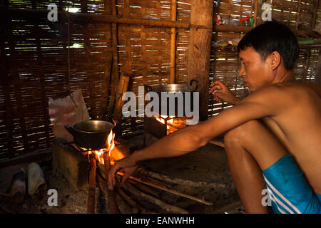 Lao Mann in seine Bambushütte Kochen Stockfoto