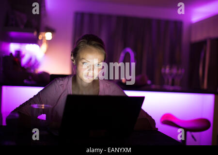 Hübsche, junge Frau tief in die Nacht Öl - aufbleiben bekomme einiges getan (Farbe getönt imagey; shallow DOF) Stockfoto