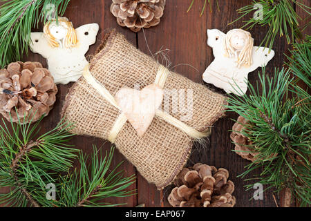 Weihnachts-Geschenk in natürlicher Stoff, verziert mit Lebkuchenherz, Engel und Kiefer Zweige gewickelt Stockfoto