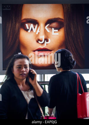 Bangkok, Bangkok, Thailand. 19. November 2014. Die Menschen gehen vorbei an einem Plakat eine Bangkok BTS Station Werbung eine Immobilien-Entwicklung. Zwischen Juli und September die Wirtschaft nur 0,6 Prozent im Vergleich zum Vorjahr wuchs, berichtet des National Economic and Social Development Board (NESDB). Thailands Wirtschaft erreicht ein schwache 0,2 Prozent Wachstum in den ersten neun Monaten des Jahres. Die NESDB sagte, dass die thailändische Wirtschaft wird voraussichtlich um 1 Prozent im Jahr 2014 wachsen. Behörden sagen, dass die langsamen Wachstums ist, weil Touristen in Thailand im Zuge des Putsches im Mai 2014, und dass nicht zurückgekehrt sind Stockfoto