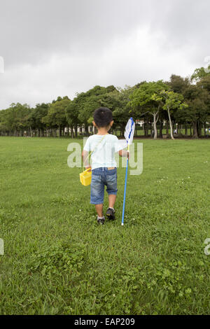 Kleiner Junge mit einem Schmetterlingsnetz. Stockfoto